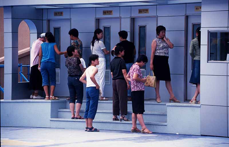 Personas hacen fila frente a los baños temporales en Shenyang, provincia de Liaoning, en el noreste de China, el 2 de julio de 2005. [Foto proporcionada a China Daily]