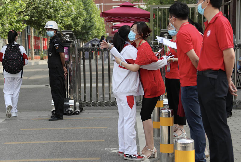 Una maestra abraza a una estudiante que se presentará al Examen Nacional de Ingreso a la Universidad, Beijing, 7 de junio del 2021. [Foto: Wang Jing/ China Daily]