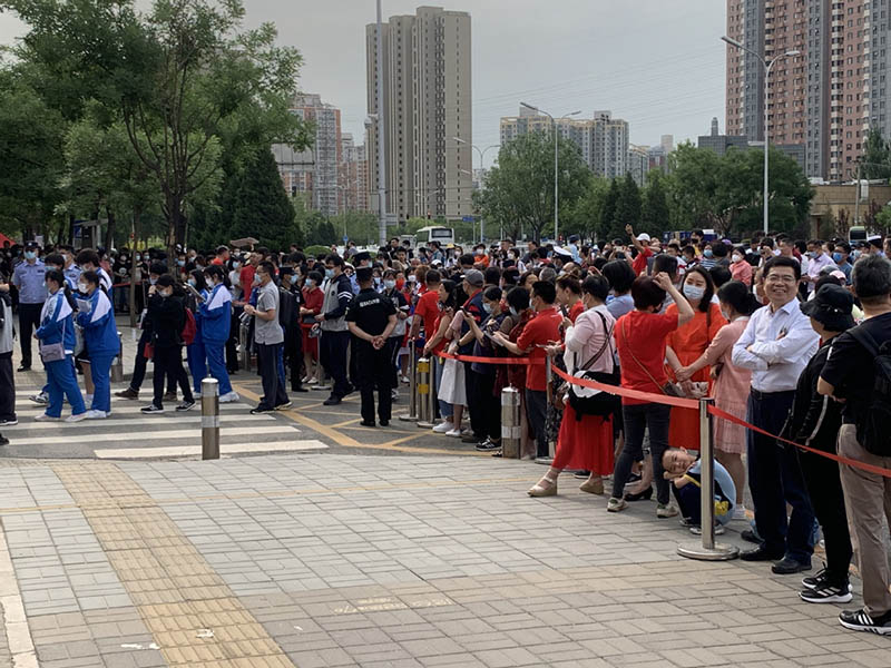 Padres y maestros aguardan la salida de los estudiantes en uno de los centros de Examen Nacional de Ingreso a la Universidad en Chaoyang, Beijing, 7 de junio del 2021. [Foto: Chen Zebing/ China Daily]