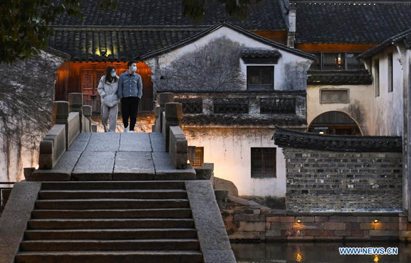 Turistas caminan sobre un puente de piedra en Wuzhen, provincia de Zhejiang, en el este de China, el 11 de enero de 2021. [Foto / Xinhua]