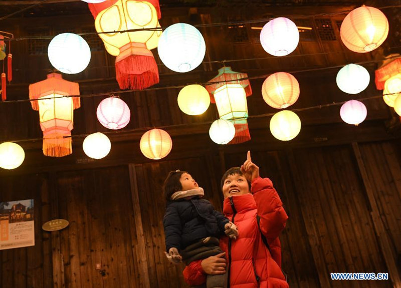 Los turistas observan los farolillos de colores en Wuzhen, provincia de Zhejiang, en el este de China, el 11 de enero de 2021. [Foto / Xinhua]