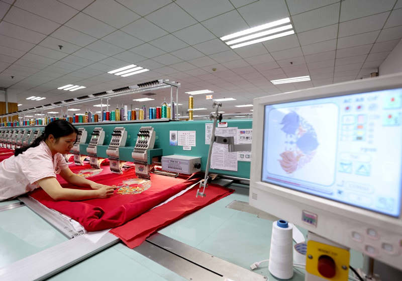 Un trabajador inspecciona los patrones de bordado en un taller situado en un parque industrial de Changsha, provincia de Hunan, 27 de mayo del 2021. [Foto: Xinhua]