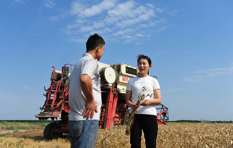 Zhang dialoga con un trabajador en su granja familiar, 22 de junio de 2021. [Foto/Xinhua]