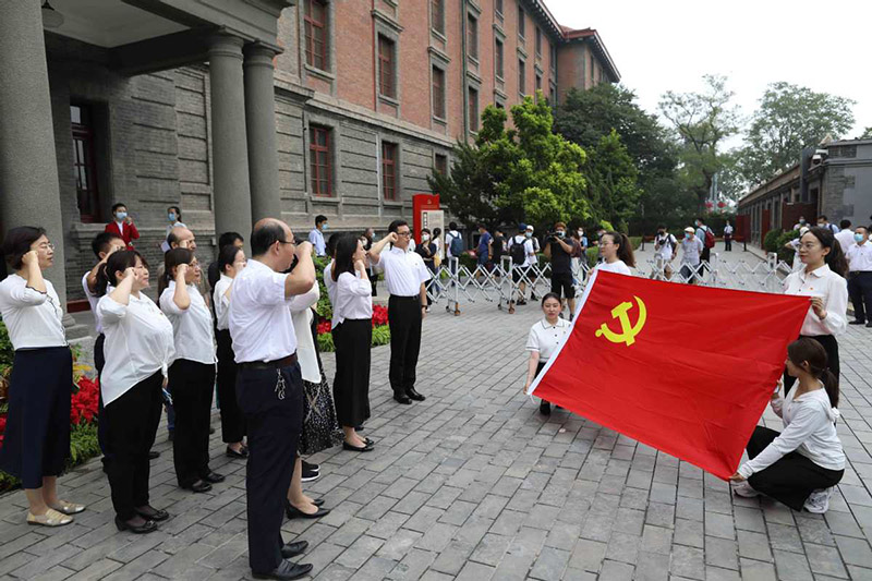 Los visitantes leen el juramento de adhesión al PCCh frente al legendario "Edificio Rojo", Beijing, 29 de junio del 2021. [Foto: Zhu Xingxin/chinadaily.com.cn]