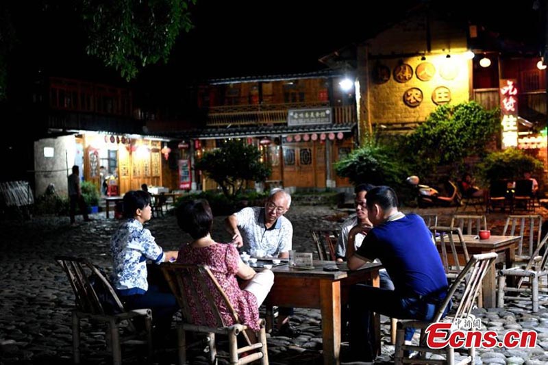 Esta foto sin fecha muestra a los residentes preparando té y charlando con turistas en un Tulou en la provincia de Fujian. (Foto / Wang Dongming)