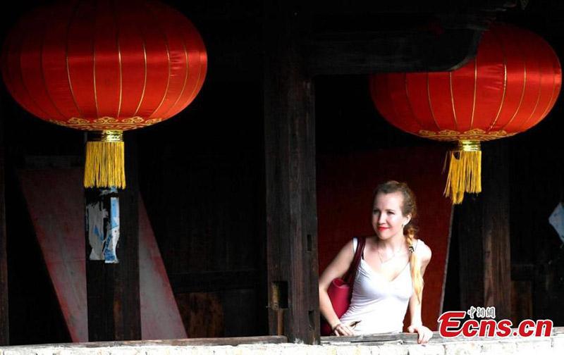 Esta foto sin fecha muestra la visita de una turista extranjera a un Tulou en la provincia de Fujian. (Foto / Wang Dongming)