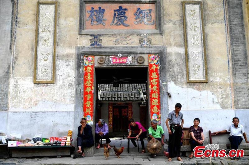 Esta foto sin fecha muestra a residentes charlando frente a un Tulou en la provincia de Fujian. (Foto / Wang Dongming)