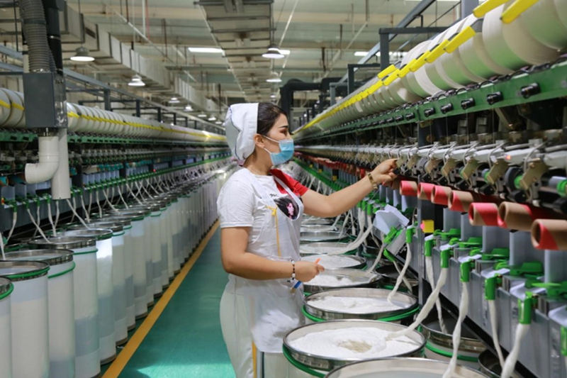 Una mujer trabaja en un taller de una fábrica textil en el condado de Awat, Aksu, en la región autónoma de Xinjiang Uygur, 10 de julio del 2021. La fábrica está preparando un pedido de 1.200 toneladas para clientes de las provincias de Shandong, Jiangsu y Zhejiang. (Foto: Pueblo en Línea/ Bao Liangting)