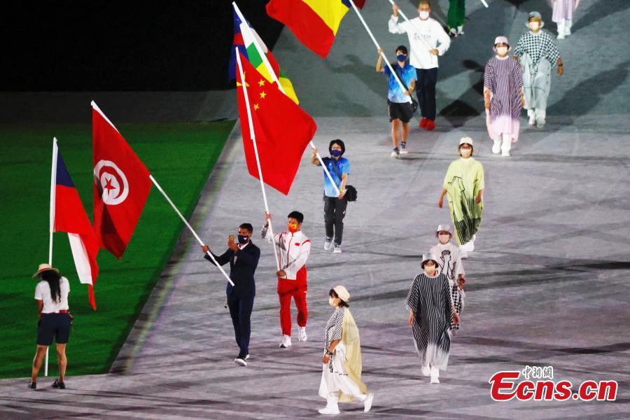 El velocista chino Su Bingtian camina por el Estadio Olímpico con la bandera nacional de China durante la ceremonia de clausura de los Juegos Olímpicos de Tokio 2020 en Japón, el 8 de agosto de 2021 (Foto: China News Service / Du Yang).