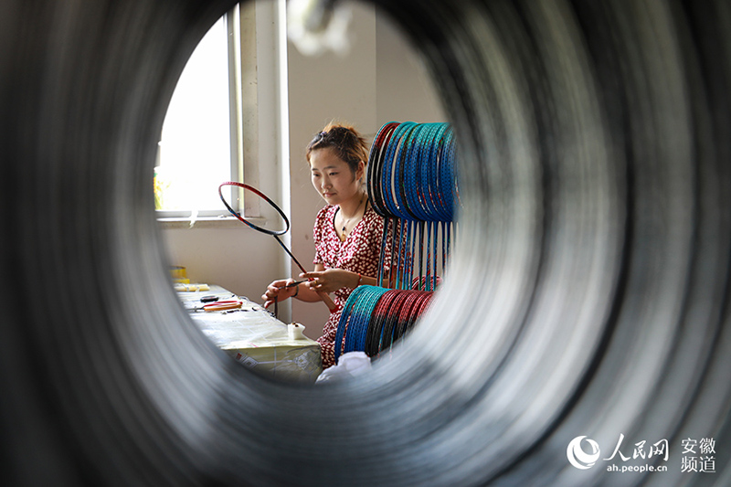 Una trabajadora fabrica una raqueta de bádminton en una fábrica del municipio de Ganchahe, condado de Shucheng, provincia de Anhui, en el este de China. (Pueblo en Línea / Zhang Jun)
