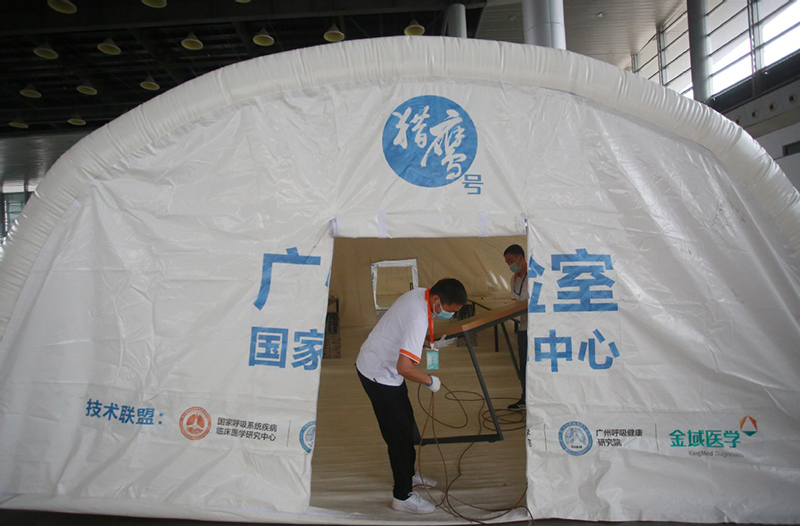 Los miembros del personal instalan un laboratorio de pruebas inflable "Falcon" para las pruebas de ácido nucleico de COVID-19 en el Centro Internacional de Exposiciones de Yangzhou, provincia de Jiangsu, en el este de China, el 10 de agosto de 2021. [Foto de Meng Delong / para China Daily]