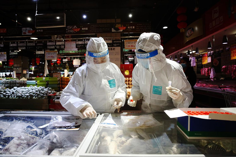 El 3 de febrero de 2021, los oficiales encargados de velar por la salud comprueban alimentos de la cadena de frío nacionales e importados en el supermercado Jiahui de Qianjiang en Chongqing, en el suroeste de China. (Yang Min / Pueblo en Línea)