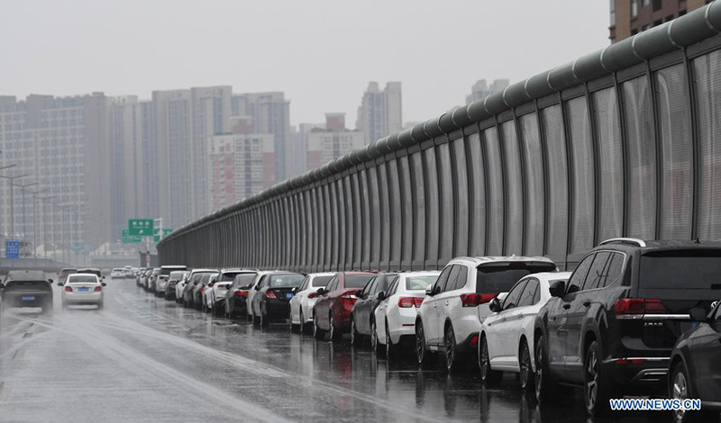 La gente estaciona vehículos en un paso elevado en Zhengzhou, capital de la provincia de Henan, en el centro de China, el 22 de agosto de 2021.(Xinhua / Zhang Haoran)