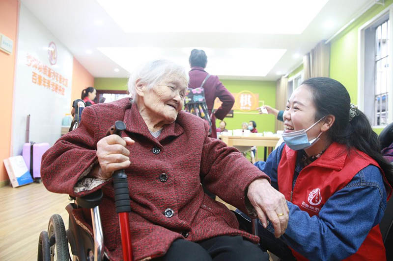 Los voluntarios hablan con una anciana en la estación de servicios para personas mayores de la comunidad de la calle Shazheng en el distrito Shapingba, ciudad de Chongqing, el 16 de octubre de 2020. Zhao Jiechang / Pueblo en Línea