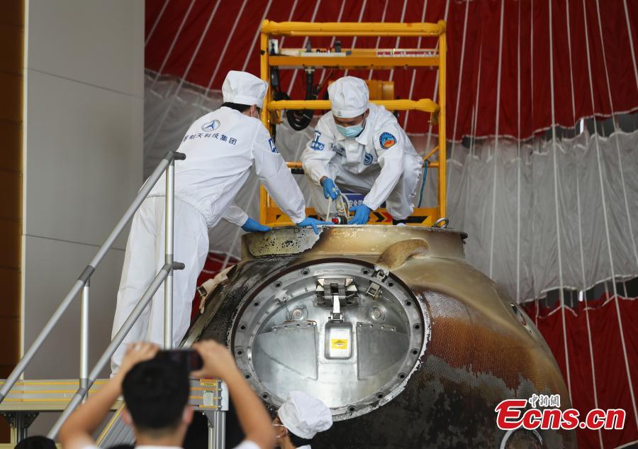 Trabajadores extraen artículos de la cápsula de retorno de la nave espacial Shenzhou-12 en una ceremonia en Beijing, 27 de septiembre del 2021. (Foto: Servicio de Noticias de China/ Zhao Jun)