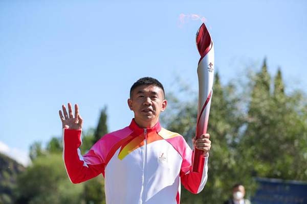 El segundo portador de la antorcha, Li Jiajun, un ex patinador chino de velocidad en pista corta, lleva la antorcha "Voladora" de los Juegos Olímpicos de Invierno de Beijing y la pasó después de recibir la antorcha el 18 de octubre. (Zheng Huansong / Xinhua)