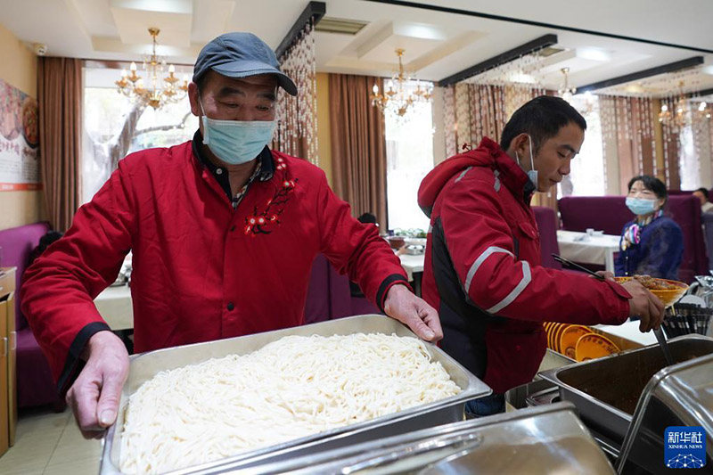 El 7 de noviembre, en el restaurante Xiaoshizao del distrito Dongcheng de Beijing, un miembro del personal llevó fideos recién cocinados a la mesa.