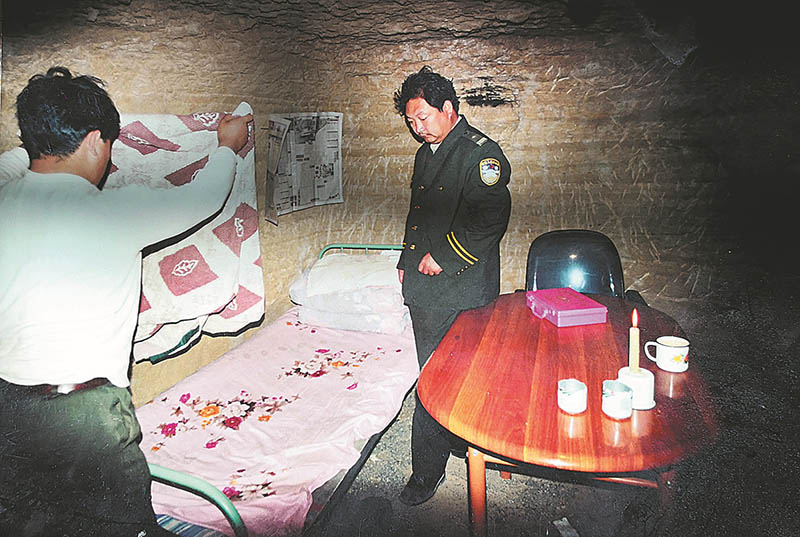 Li revisa la cama de un oficial de policía a principios de la década de 2000, cuando la cueva aún no se había cavado por completo y estaba casi sin amueblar. Foto proporcionada a CHINA DAILY
