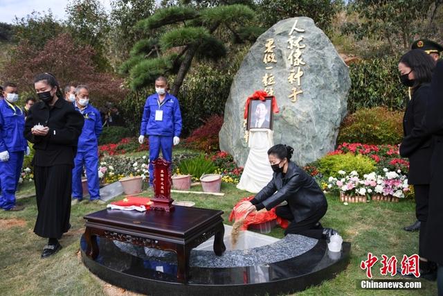 Un miembro de la familia arroja tierra a la tumba de Yuan Longping en la ceremonia de entierro celebrada en Changsha, provincia de Hunan, el 15 de noviembre. [Foto / Chinanews.com]