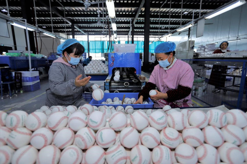 El 18 de noviembre de 2021, varios trabajadores hacían su jornada en la fábrica de una empresa de equipamiento deportivo en el condado Dushan, provincia de Guizhou. Los trabajadores trabajan fabricando pelotas de béisbol para venderlas en el extranjero. Imagen de Mo Yu / Pueblo en Línea