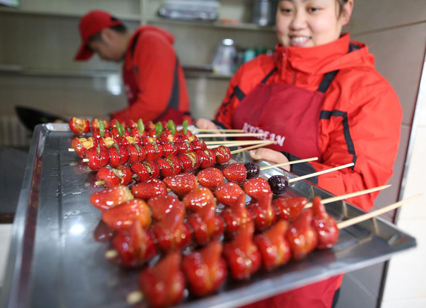 Residente en la provincia de Jilin vende espinos recubiertos de azúcar. [Foto : Baishi/ Chinadaily.com.cn]