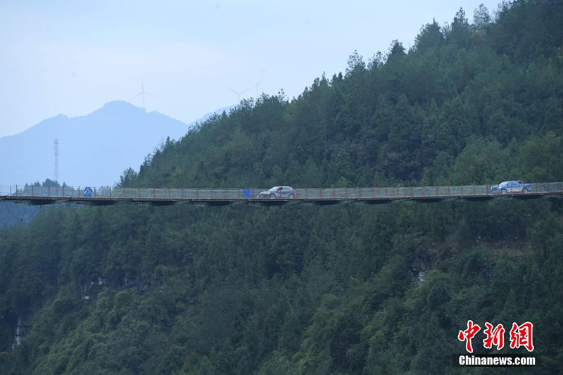 El 17 de diciembre, vehículos pasaron por un puente colgante en las montañas del distrito Wulong, ciudad de Chongqing.