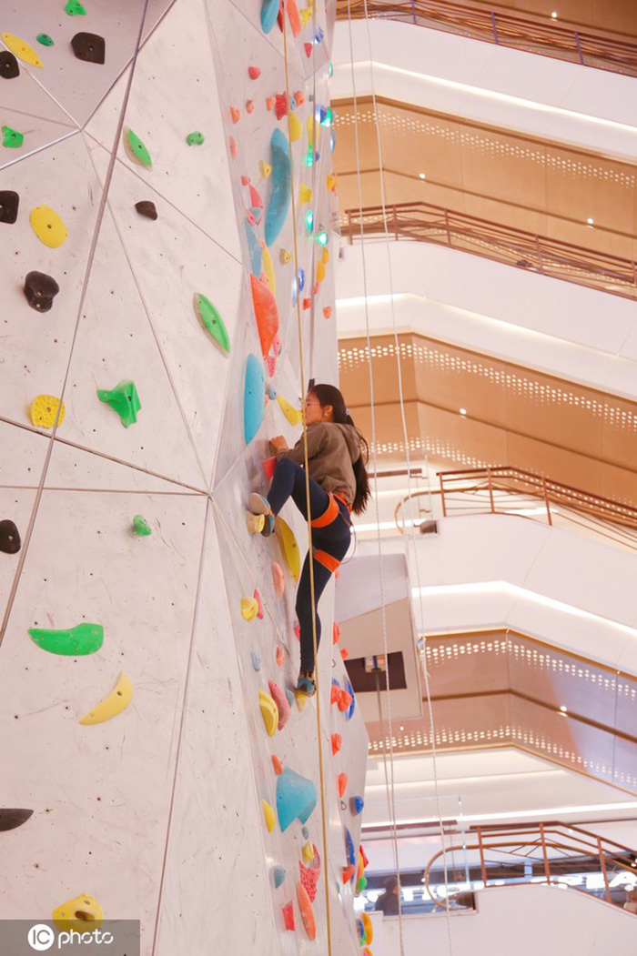 Los entusiastas de los deportes extremos experimentan la escalada en roca en un centro comercial de Shanghai, 19 de diciembre del 2021. [Foto: IC]