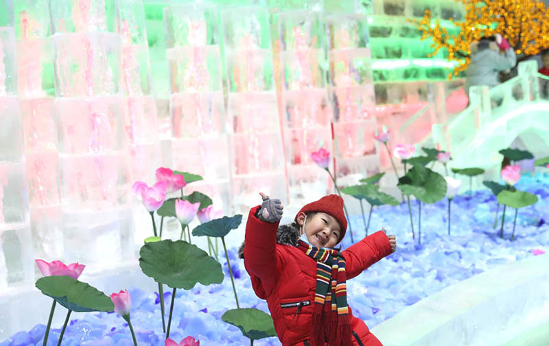 Un niño admira esculturas de hielo en la Garganta Longqing, 15 de enero del 2022. [Foto: Zou Hong/China Daily]