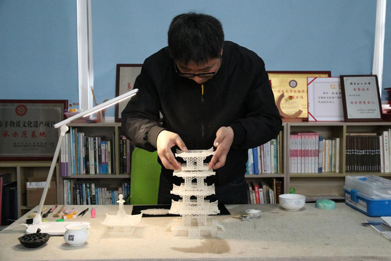 El artista popular Chen Guorui hace una pagoda usando alrededor de 12 500 granos de arroz. [Foto proporcionada a chinadaily.com.cn]