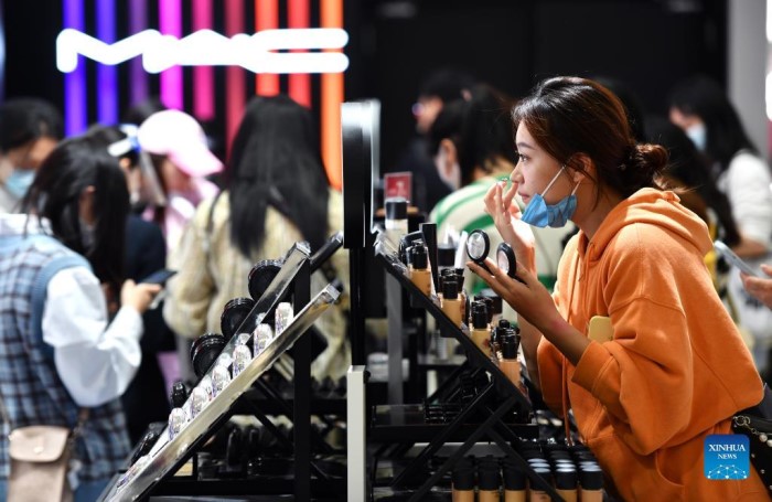 Una chica prueba productos cosméticos en una tienda libre de impuestos en Haikou, capital de la provincia de Hainan, 3 de enero del 2022. [Foto: Xinhua]