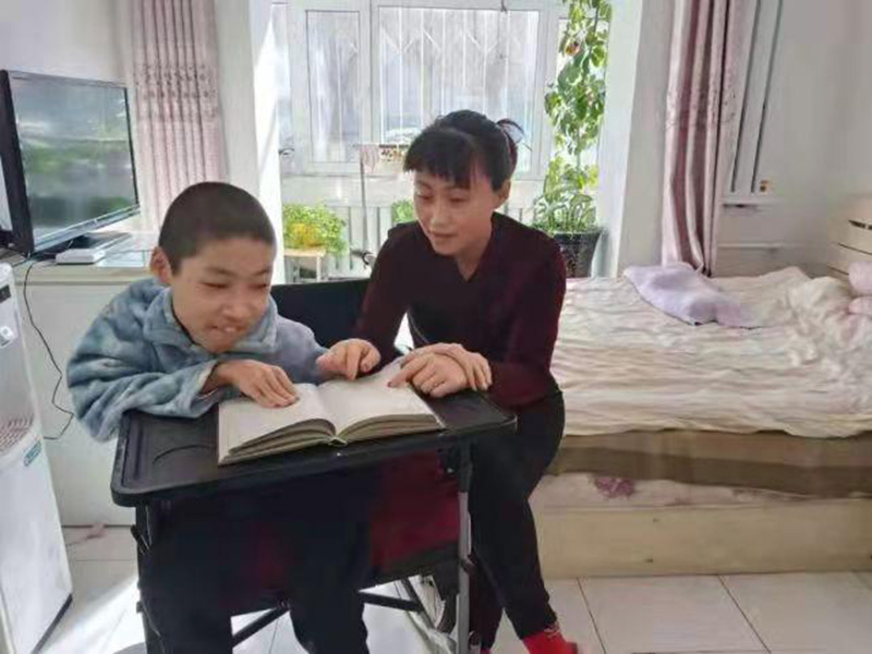 Bi Yu y Wang Weikang leyendo un libro en casa. [Foto: proporcionada a chinadaily.com.cn]