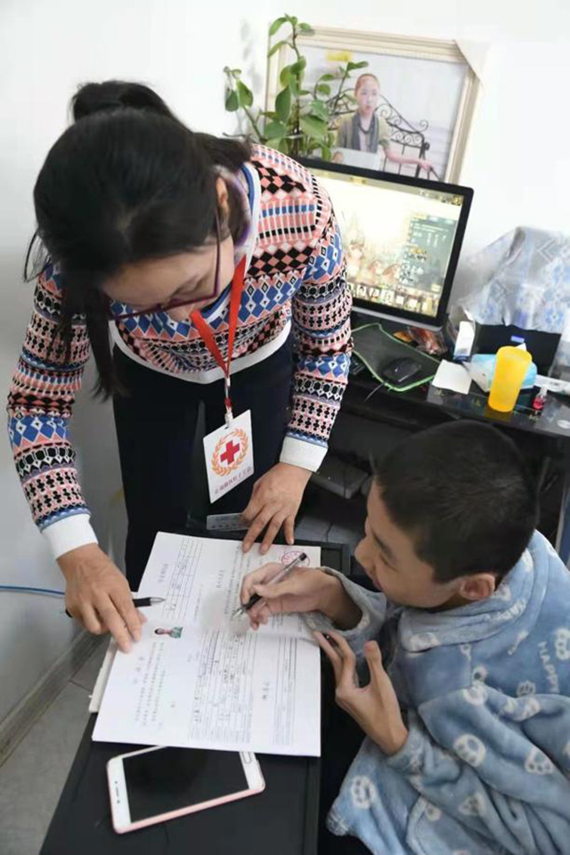 Wang Weikang firma un formulario para la donación de sus córneas. [Foto: proporcionada a chinadaily.com.cn]