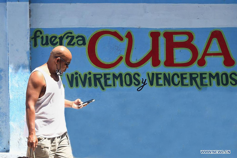 Un hombre utiliza su teléfono móvil mientras camina por una calle, en La Habana, capital de Cuba, el 22 de marzo de 2022. El Gobierno cubano impulsa un ambicioso proceso de informatización de la sociedad, el cual no sólo busca modernizar los procesos de gobernanza, administrativos y económicos, sino que se centra en favorecer la vida de la ciudadanía. (Xinhua/Joaquín Hernández)