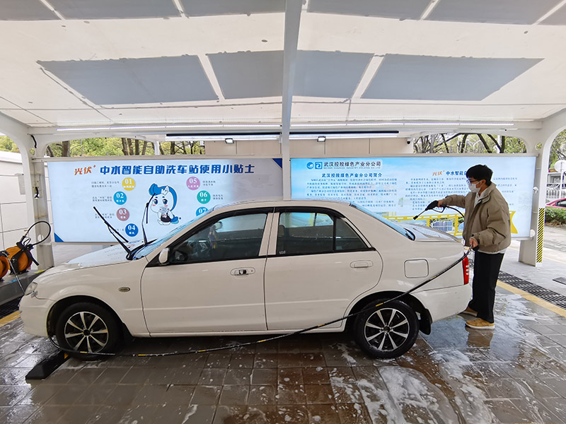 Un hombre experimenta el servicio de lavado de coches de autoservicio en una estación en Wuhan, el 23 de marzo de 2022. [Foto/IC]
