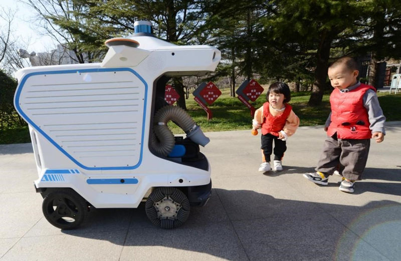 El 20 de diciembre de 2021, en el parque Zhengzhou Zhilin, nuevo distrito de Zhengdong, ciudad de Zhengzhou, los niños observaban el robot de limpieza inteligente de segunda generación que acababa de entrar en operación. Zhang Tao/Pueblo en Línea