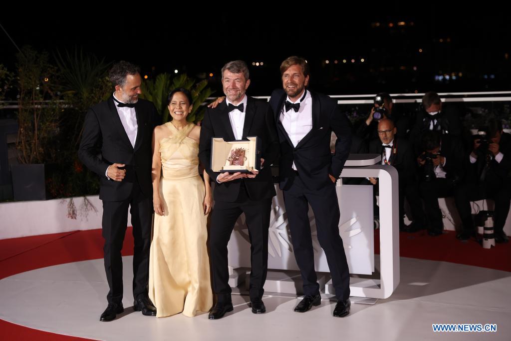 Imagen del 28 de mayo de 2022 del director sueco Ruben Ostlund (d) posando con integrantes del elenco durante una sesión fotográfica después de que su película "Triangle of Sadness" ganara la Palma de Oro en la ceremonia de clausura de la edición 75 del Festival Internacional de Cine de Cannes, en Cannes, en el sur de Francia. (Xinhua/Gao Jing)