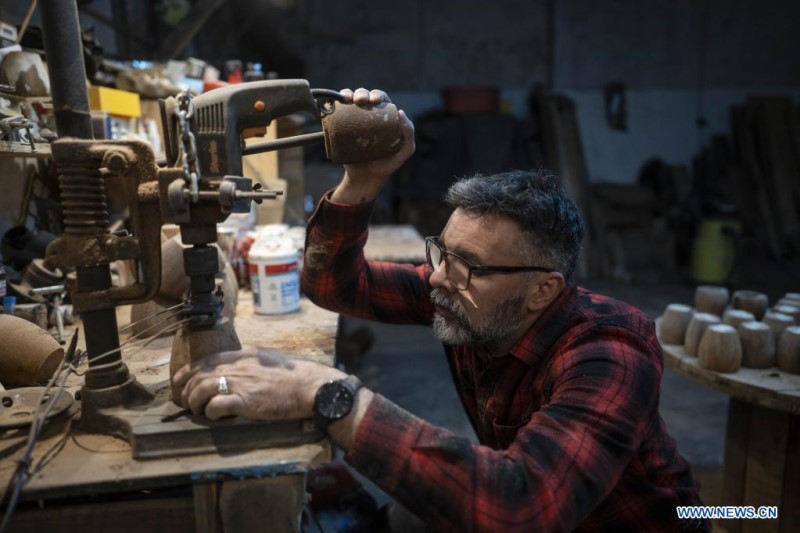  El artesano Alejandro Gats, conocido como "Sasha", imprime su nombre en un recipiente para mate, en su taller, en Buenos Aires, Argentina, el 9 de junio de 2022. Un artesano argentino resguarda y reinterpreta en el país sudamericano la tradición del mate, la popular infusión del Río de la Plata, mediante la confección de elegantes recipientes a partir de maderas que provienen de árboles de la región, como el algarrobo o el anchico. (Xinhua/Martín Zabala)