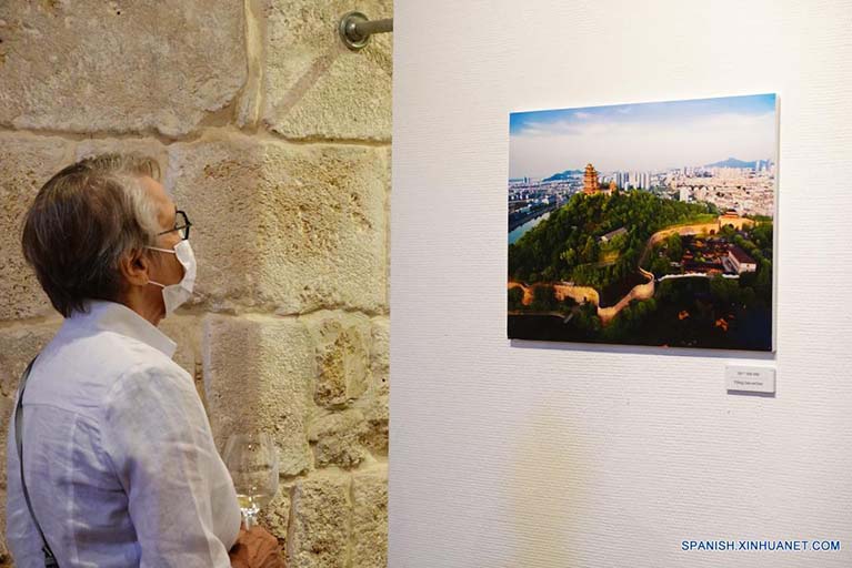 Imagen del 13 de junio de 2022 de un hombre visitando una exposición fotográfica de las murallas de la ciudad de la antigua capital china, Nanjing, y de la milenaria ciudad israelí de Akko, en la ciudad vieja de Akko, en el norte de Israel. Una exposición fotográfica de las murallas de la antigua capital china, Nanjing, y de la milenaria ciudad israelí de Akko se inauguró el lunes. La exposición, organizada conjuntamente por el Centro Cultural de China en Tel Aviv, la Municipalidad de Akko y otros organismos de ambos países, muestra unas 40 fotografías de Nanjing, la capital de seis dinastías de la antigua China, y Akko, uno de los primeros lugares históricos de Israel seleccionados como patrimonio cultural de la humanidad. (Xinhua/Wang Zhuolun)