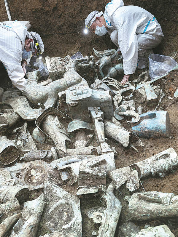 Dos investigadores trabajan en un pozo de sacrificio en Sanxingdui, Guanghan, provincia de Sichuan, 31 de mayo del 2022. [Foto: Yu Jia/ China Daily]