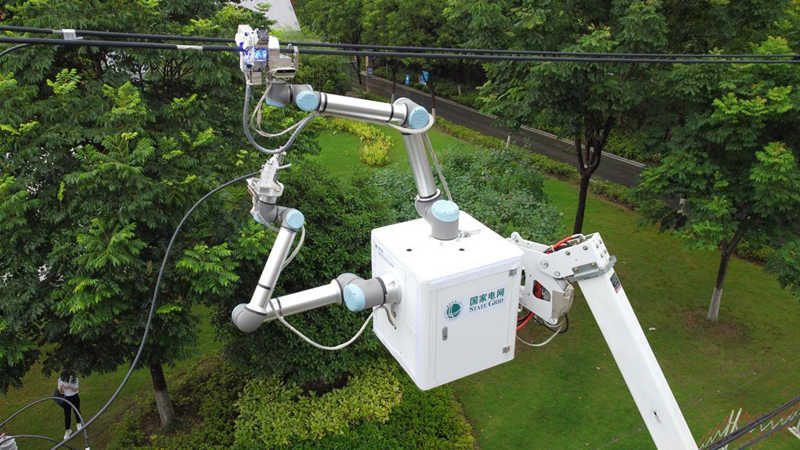 Un robot desarrollado en el país trabaja esteviernes en líneas eléctricas aéreas en el distrito Qingshan de Wuhan, provincia de Hubei. [Foto: proporcionada a chinadaily.com.cn]