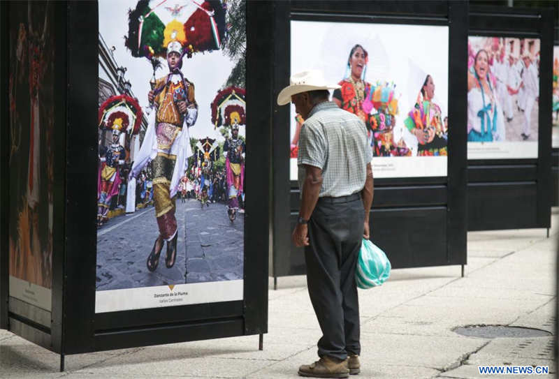  Un hombre observa una fotografía durante la inauguración de la exposición "La Guelaguetza, Fiesta, Diversidad y Armonía", en la Ciudad de México, capital de México, el 4 de julio de 2022. (Xinhua/Francisco Cañedo) 