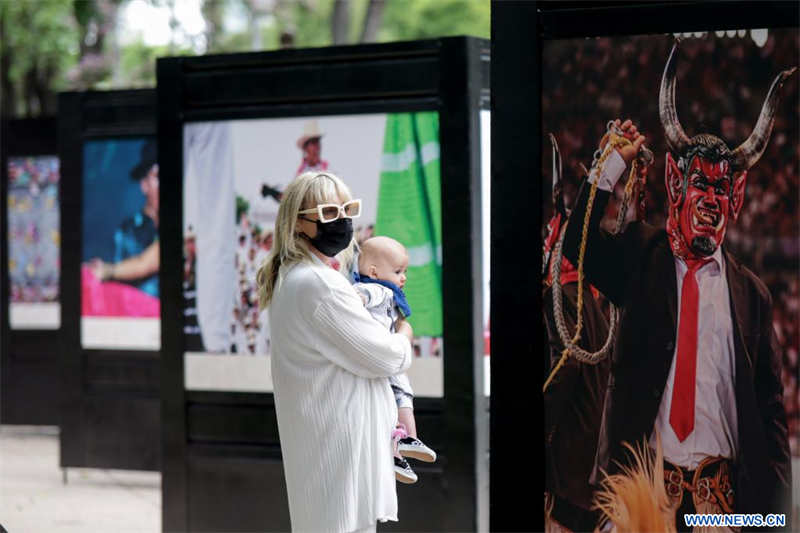 Una mujer observa una fotografía durante la inauguración de la exposición "La Guelaguetza, Fiesta, Diversidad y Armonía", en la Ciudad de México, capital de México, el 4 de julio de 2022. (Xinhua/Francisco Cañedo)