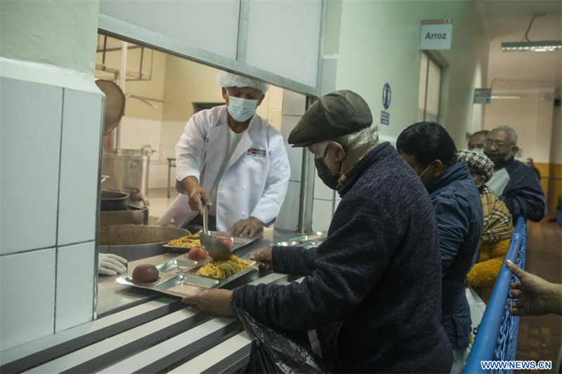 Personas reciben alimentos en el Centro de Alimentación y Nutrición N°3, en Lima, Perú, el 11 de julio de 2022. Decenas de peruanos en situación de vulnerabilidad acuden diariamente al Centro de Alimentación y Nutrición N°3, un comedor popular que, ubicado en el distrito limeño de La Victoria, resulta un alivio económico al ofrecer desayunos y almuerzos a bajo costo. (Xinhua/Mariana Bazo)
