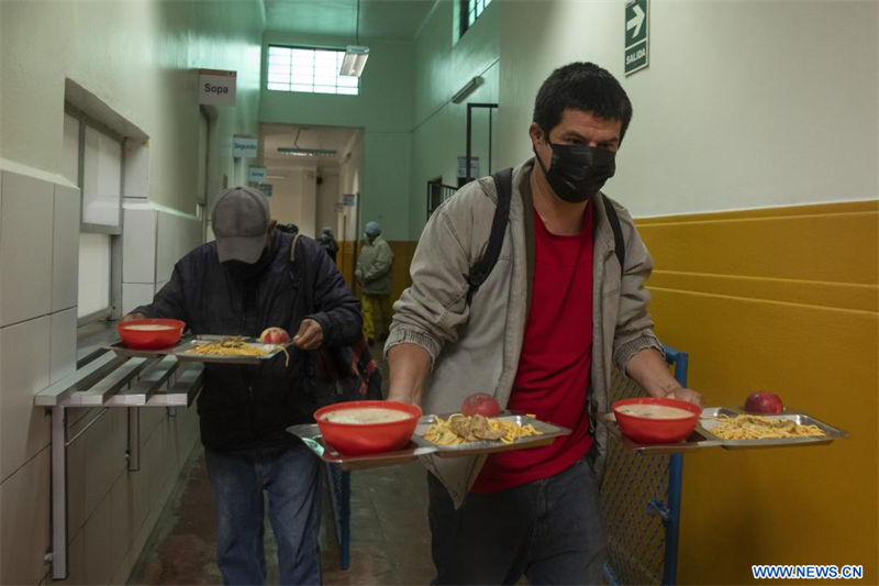 Personas llevan raciones de alimentos en el Centro de Alimentación y Nutrición N°3, en Lima, Perú, el 11 de julio de 2022. Decenas de peruanos en situación de vulnerabilidad acuden diariamente al Centro de Alimentación y Nutrición N°3, un comedor popular que, ubicado en el distrito limeño de La Victoria, resulta un alivio económico al ofrecer desayunos y almuerzos a bajo costo. (Xinhua/Mariana Bazo)