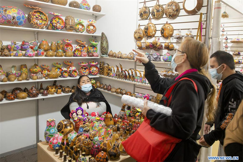  Personas observan los productos exhibidos durante la Feria Nacional de Artesanía "De Nuestras Manos", en el parque Kennedy de Miraflores, en Lima, Perú, el 17 de agosto de 2022. Con la participación de alrededor de 100 artesanos de todo el país, la feria se lleva a cabo hasta el 21 de agosto. (Xinhua/Mariana Bazo)