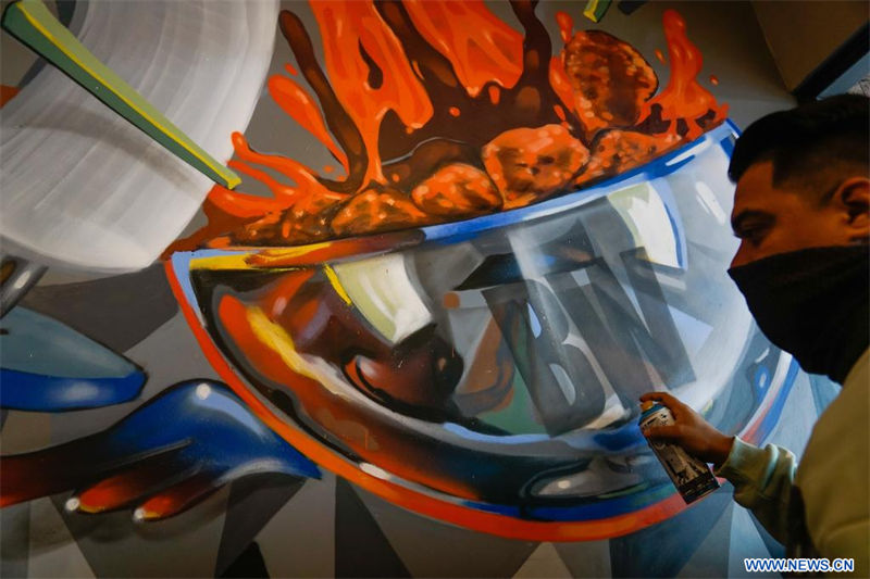 El artista urbano salvadoreño Efraín Orellana, conocido como "TNT", pinta un mural, en el departamento de San Salvador, El Salvador, el 18 de agosto de 2022. Orellana pertenece a un movimiento enfocado en alejar a los jóvenes de las armas y acercarlos al arte y las latas de aerosol. (Xinhua/Alexander Peña)