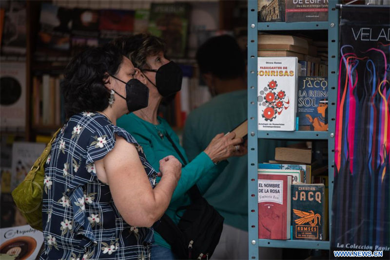  Mujeres observan libros en un estand durante la 13 Feria del Libro de Caracas en el Parque Los Caobos, en Caracas, Venezuela, el 20 de agosto de 2022. La 13 edición de la feria fue inaugurada el sábado en el Parque Los Caobos de Caracas con el eslogan "Volvemos a leernos" regresando a su formato presencial luego de llevarse a cabo en formato virtual por dos años consecutivos debido a la pandemia de la enfermad del nuevo coronavirus (COVID-19). (Xinhua/Marcos Salgado) 