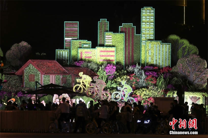 Se iluminan los adornos de flores con el tema del Día Nacional en Beijing