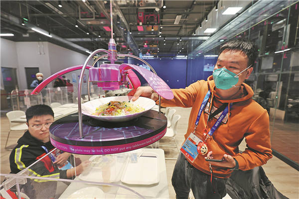 Un cliente recoge comida de un dispositivo perteneciente al restaurante "inteligente" del principal centro de medios de prensa durante los Juegos Olímpicos de Invierno Beijing 2022, enero del 2022. (Foto: Agencia de Noticias Yonhap) 