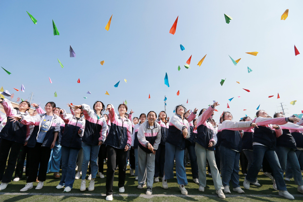 Estudiantes de último año de secundaria lanzan aviones de papel para vencer el estrés antes del examen en la ciudad de Huaibei, provincia de Anhui, el 31 de mayo de 2023. [Foto/Xinhua]